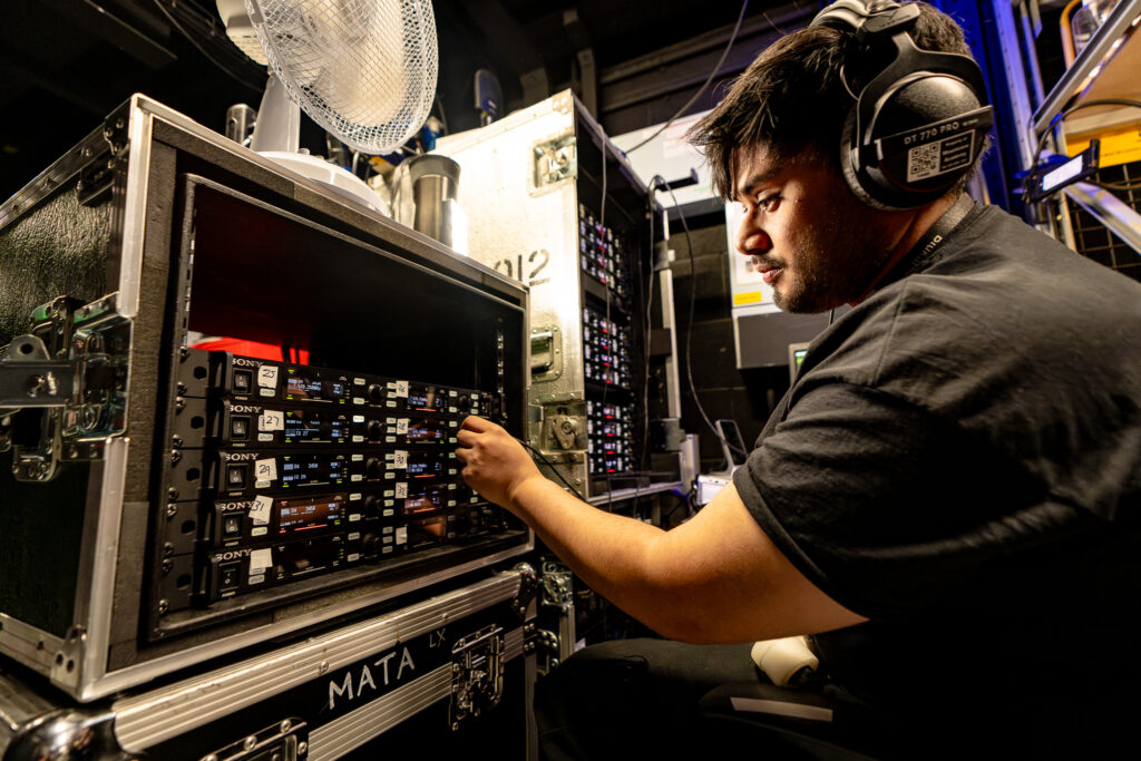 A student adjusting radio mics in the Technical Production course at Mountview.